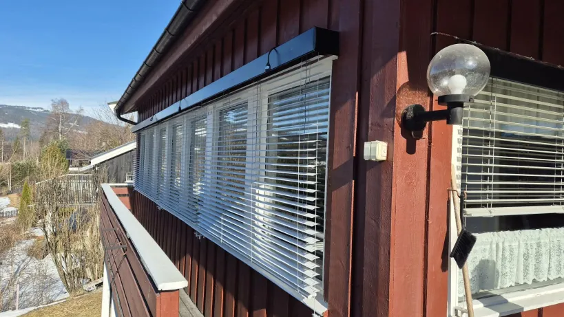 Utvendige persienner på rødt hus